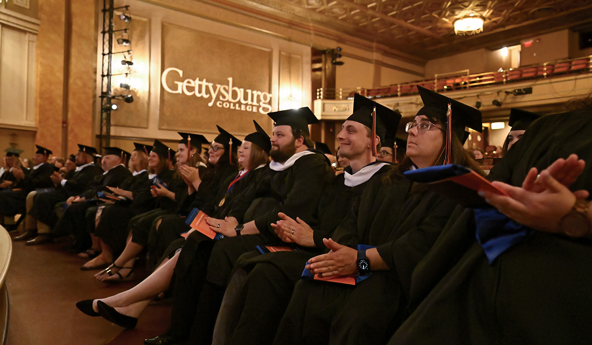 An image of graduates clapping