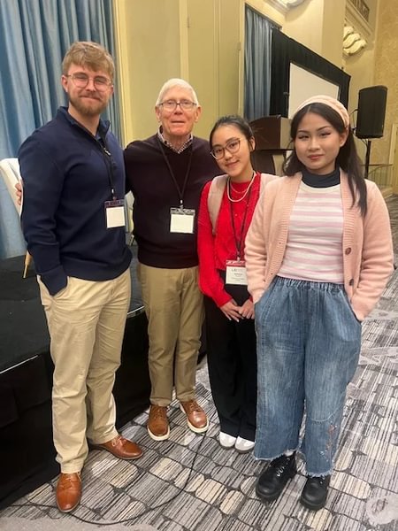 Three student Leadership Educators meet with Dr. Dennis C. Roberts at the 2024 Leadership Educators Institute conference.