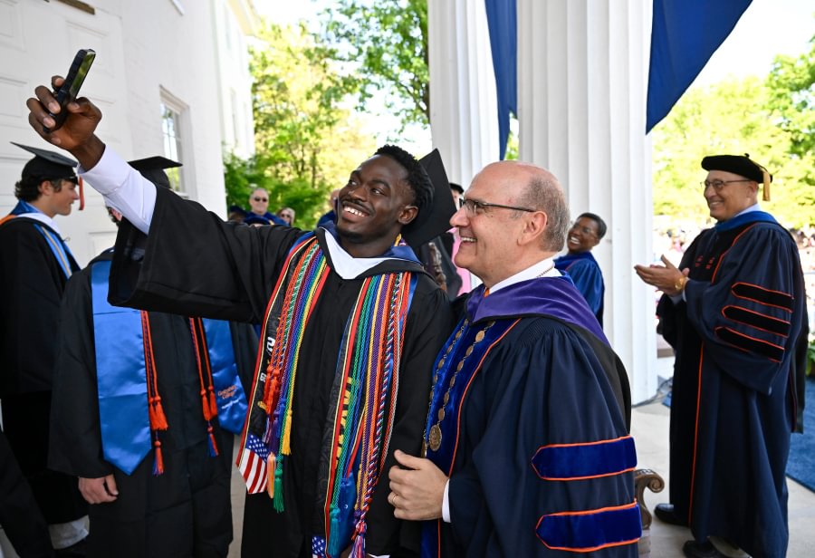 A graduate taking a selfie with President Bob