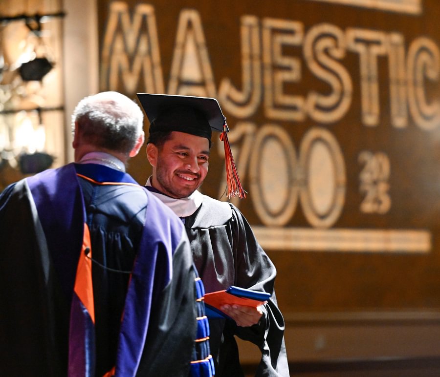 President Bob Iuliano presents a Stole of Gratitude to a master's graduate.