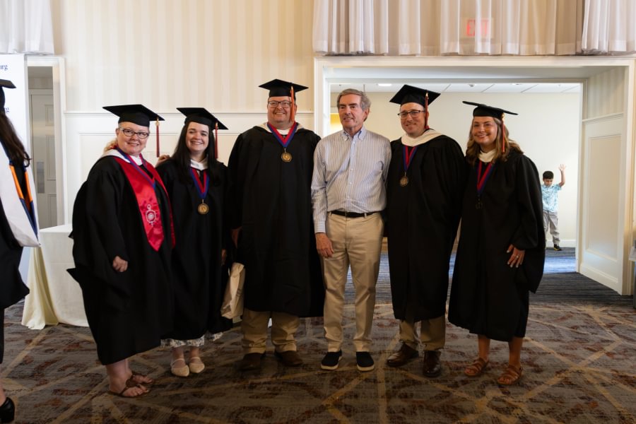 Master's graduates pose for a photo with GLI President and CEO Jim Basker.