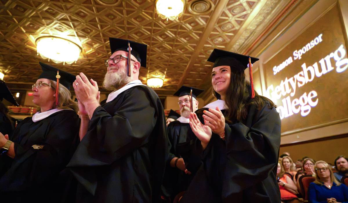 An image of graduates clapping