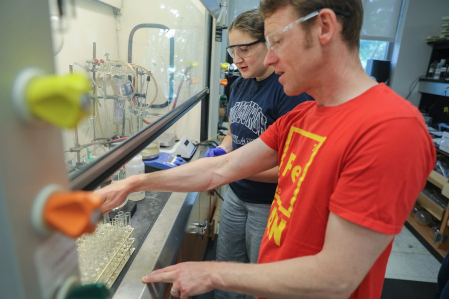 Chemistry and Biochemistry Prof. Timothy Funk &rsquo;00 works inside his lab with a student